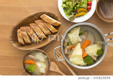 木製テーブルに並ぶ温かいポトフとバゲットの食卓 真上からの俯瞰 木製テーブルに並ぶ温かいポトフとバゲットの食卓 真上からの俯瞰 141623059