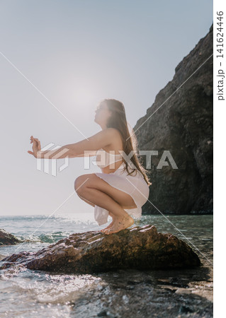 Woman meditation yoga practicing mindfulness on seaside stones with serenity and balance during golden hour Woman meditation yoga practicing mindfulness on seaside stones with serenity and balance during golden hour 141624446