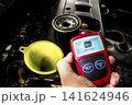 Car engine maintenance with oil filter, funnel, and OBD2 diagnostic scanner  141624946
