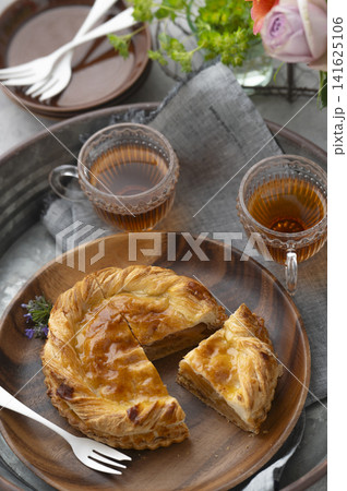 トレイに並ぶカットされたアップルパイと紅茶のティータイム(バラの花束と食卓) トレイに並ぶカットされたアップルパイと紅茶のティータイム(バラの花束と食卓) 141625106