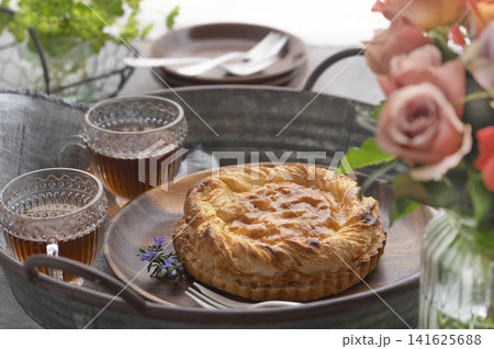 バラの花束とトレイに並ぶ焼きたてアップルパイと紅茶のティータイム 141625688