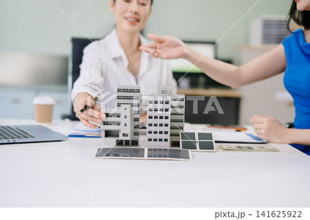 Professional real estate advisor consulting a client on property investment, housing insurance, and home ownership. Asian people in a modern office. Professional real estate advisor consulting a client on property investment, housing insurance, and home ownership. Asian people in a modern office. 141625922