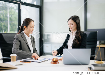 Asian lawyer and client shaking hands after signing a business contract in a modern office, symbolizing trust, legal agreement, partnership Asian lawyer and client shaking hands after signing a business contract in a modern office, symbolizing trust, legal agreement, partnership 141626010