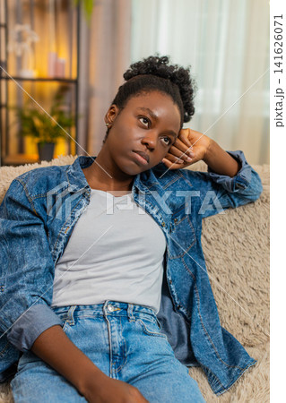 African American woman stressed on sofa thinking after bad day, financial failure or personal issues African American woman stressed on sofa thinking after bad day, financial failure or personal issues 141626071