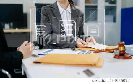 Professional attorney reviewing contract files and checklist icons, representing legal compliance, audit, and document approval. Professional attorney reviewing contract files and checklist icons, representing legal compliance, audit, and document approval. 141626093
