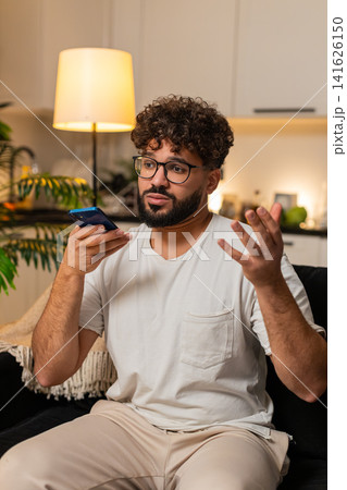 Arabian man on smartphone speakerphone call calm tone asks follow up questions listens to friend yes 141626150