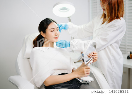Dermatologist Injecting Botox or Facial Filler Treatment for Young Asian Woman at Aesthetic Clinic Dermatologist Injecting Botox or Facial Filler Treatment for Young Asian Woman at Aesthetic Clinic 141626531