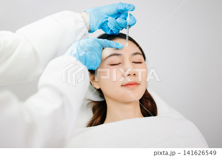 Dermatologist Injecting Botox or Facial Filler Treatment for Young Asian Woman at Aesthetic Clinic Dermatologist Injecting Botox or Facial Filler Treatment for Young Asian Woman at Aesthetic Clinic 141626549