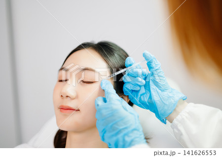 Dermatologist Injecting Botox or Facial Filler Treatment for Young Asian Woman at Aesthetic Clinic Dermatologist Injecting Botox or Facial Filler Treatment for Young Asian Woman at Aesthetic Clinic 141626553
