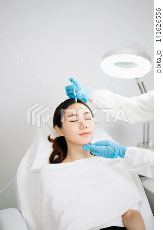 Dermatologist Injecting Botox or Facial Filler Treatment for Young Asian Woman at Aesthetic Clinic Dermatologist Injecting Botox or Facial Filler Treatment for Young Asian Woman at Aesthetic Clinic 141626556