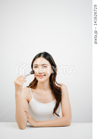Asian woman holding lipstick with clean minimal style, soft light and natural beauty look for cosmetic advertising Asian woman holding lipstick with clean minimal style, soft light and natural beauty look for cosmetic advertising 141626729