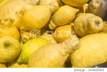 Ugly lemons in a wooden crate on a market counter. Supermarket counters. Ugly lemons in a wooden crate on a market counter. Supermarket counters. 141626951