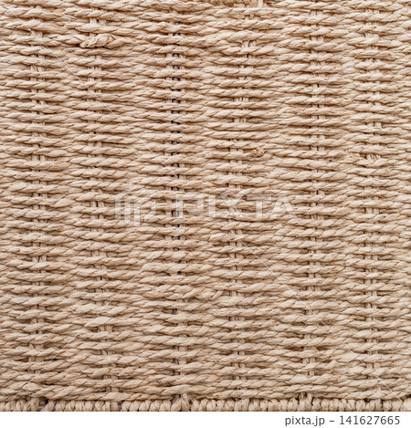 Macro texture background of beige basket woven from twisted paper rope with horizontal rows Macro texture background of beige basket woven from twisted paper rope with horizontal rows 141627665