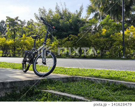 Folding Bicycle Parked on a Sunny Sidewalk Folding Bicycle Parked on a Sunny Sidewalk 141628479