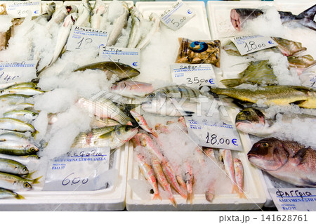 Assortment of fresh fish displayed on ice at a market stall Assortment of fresh fish displayed on ice at a market stall 141628761
