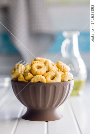 Bowl of Savory Taralli Ring Snacks on White Table with Olive Oil and Rustic Cloth Bowl of Savory Taralli Ring Snacks on White Table with Olive Oil and Rustic Cloth 141628892