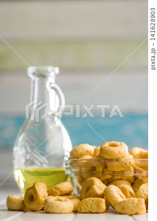 Taralli Italian Crackers With Olive Oil in Bowl On Kitchen Table Rustic Savory Snack Taralli Italian Crackers With Olive Oil in Bowl On Kitchen Table Rustic Savory Snack 141628903