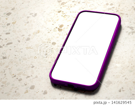 A smartphone with a blank white screen and pink frame lies diagonally on a terrazzo tile floor, A smartphone with a blank white screen and pink frame lies diagonally on a terrazzo tile floor, 141629545