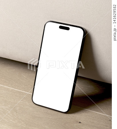Blank smartphone mockup on a wooden floor. Angled mobile phone with white screen in an indoor setting. Ideal for app design, advertising, and technology branding.. 141629582