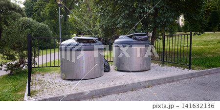 Waste bins placed near a path in a green park area on a sunny day Waste bins placed near a path in a green park area on a sunny day 141632136