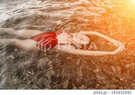 Woman floating water serene woman enjoying tranquil moment in clear ocean. Woman floating water serene woman enjoying tranquil moment in clear ocean. 141632891
