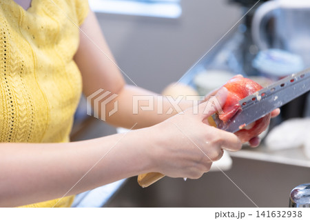 桃の皮をむく30代女性の手元 桃の皮をむく30代女性の手元 141632938