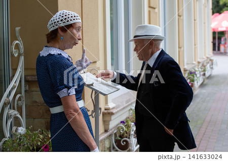 Older couple discussing menu outside a vintage cafe in a charming town during a sunny afternoon Older couple discussing menu outside a vintage cafe in a charming town during a sunny afternoon 141633024