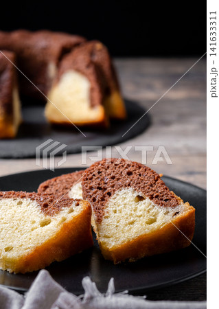 Marble bundt cake sliced on rustic wooden table 141633311