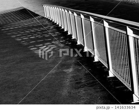 Monochrome railing creates bold linear shadow pattern Monochrome railing creates bold linear shadow pattern 141633634