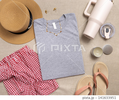 Blank heather grey folded shirt mockup with woman summer accessories, template with copy space Blank heather grey folded shirt mockup with woman summer accessories, template with copy space 141633951