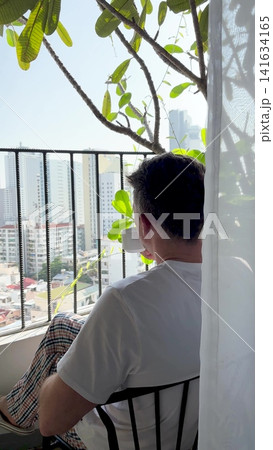 Man enjoys coffee on a balcony 141634165