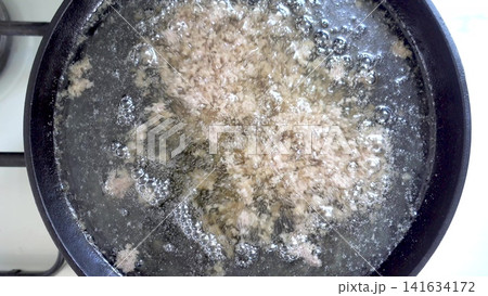 Rendering animal fat in a black frying pan Rendering animal fat in a black frying pan 141634172