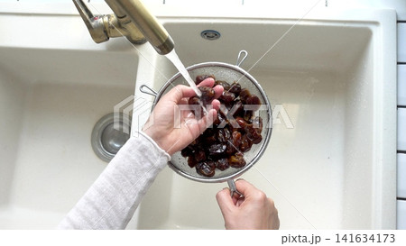 Female hands wash dried dates Female hands wash dried dates 141634173