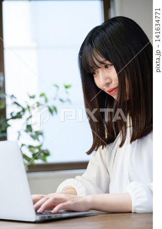 オフィスでノートパソコンを使う若いビジネスウーマン オフィスでノートパソコンを使う若いビジネスウーマン 141634771