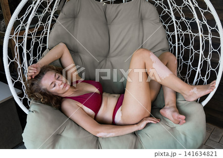 Mature woman with vitiligo skin and gray hair.  Female with autoimmune disease. pigmentation.  scene radiates tranquility, self love, and body positivity, capturing the essence of embracing  141634821