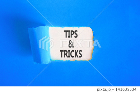 Tips and tricks words symbol. Concept words Tips and tricks on beautiful white paper. Beautiful blue background. Business tips and tricks motivational support concept. Copy space. Tips and tricks words symbol. Concept words Tips and tricks on beautiful white paper. Beautiful blue background. Business tips and tricks motivational support concept. Copy space. 141635334