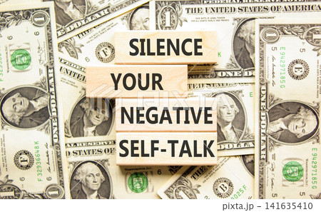 Silence your negative self-talk symbol. Concept words Silence your negative self-talk on beautiful wooden blocks. Beautiful dollar bills background. Psychological negative self-talk concept Copy space Silence your negative self-talk symbol. Concept words Silence your negative self-talk on beautiful wooden blocks. Beautiful dollar bills background. Psychological negative self-talk concept Copy space 141635410