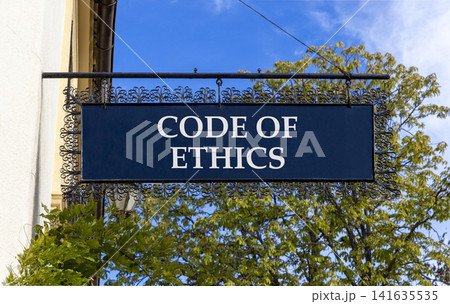 Code of ethics words symbol. Concept words Code of ethics on beautiful black road sign. Beautiful blue sky green tree background. Business Code of ethics concept. Copy space. Code of ethics words symbol. Concept words Code of ethics on beautiful black road sign. Beautiful blue sky green tree background. Business Code of ethics concept. Copy space. 141635535
