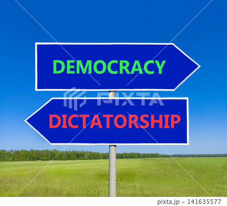 Democracy or dictatorship words symbol. Concept words Democracy Dictatorship on beautiful blue road sign. Beautiful blue sky background. Business democracy dictatorship concept. Copy space Democracy or dictatorship words symbol. Concept words Democracy Dictatorship on beautiful blue road sign. Beautiful blue sky background. Business democracy dictatorship concept. Copy space 141635577