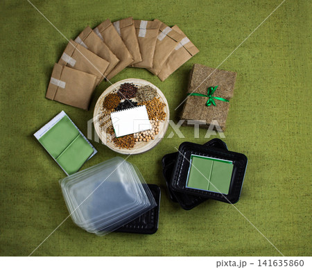 Microgreens cultivation set with sprouted trays and eco materials. Organized layout includes seed packets, fiber mats, and trays with growing greens. Microgreens cultivation set with sprouted trays and eco materials. Organized layout includes seed packets, fiber mats, and trays with growing greens. 141635860
