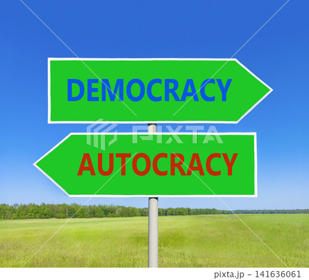 Democracy or autocracy words symbol. Concept words Democracy Autocracy on beautiful green road sign. Beautiful blue sky background. Business democracy autocracy concept. Copy space Democracy or autocracy words symbol. Concept words Democracy Autocracy on beautiful green road sign. Beautiful blue sky background. Business democracy autocracy concept. Copy space 141636061