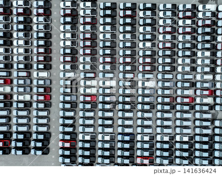 Aerial view vehicle assembly plant parking lot packed with cars, pickup truck, and SUV. Logistics, transportation strategy, electric and hybrid vehicle production. Trade agreements and tariffs. Aerial view vehicle assembly plant parking lot packed with cars, pickup truck, and SUV. Logistics, transportation strategy, electric and hybrid vehicle production. Trade agreements and tariffs. 141636424