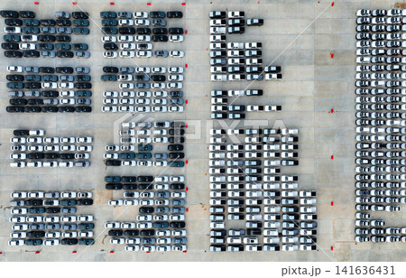 Aerial view of new cars stock at factory parking lot. Above view cars parked in a row. Automotive industry. Logistics business. Import or export new cars at warehouse. Big parking lot at port terminal Aerial view of new cars stock at factory parking lot. Above view cars parked in a row. Automotive industry. Logistics business. Import or export new cars at warehouse. Big parking lot at port terminal 141636431