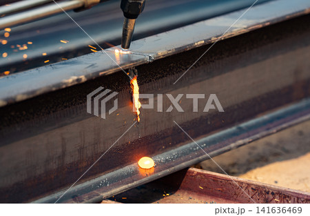 Welder working on metal beam, emitting bright sparks as part of welding process. Skilled labor. Danger of industrial work, and craftsmanship required in metal fabrication. Skilled hands control flame. Welder working on metal beam, emitting bright sparks as part of welding process. Skilled labor. Danger of industrial work, and craftsmanship required in metal fabrication. Skilled hands control flame. 141636469