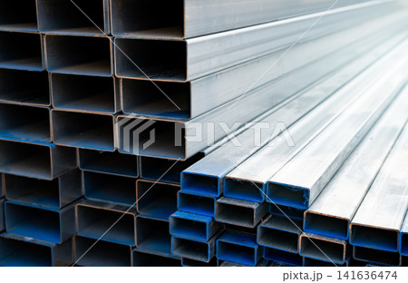 Industrial warehouse stock of rectangular metal pipes for building and construction supplies. Stack of steel pipes. Iron materials for construction and infrastructure projects. Steel tubing storage. Industrial warehouse stock of rectangular metal pipes for building and construction supplies. Stack of steel pipes. Iron materials for construction and infrastructure projects. Steel tubing storage. 141636474