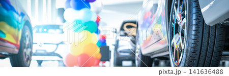Car parked in luxury showroom. Car dealership office decorate with balloons. New car parked in modern showroom. Car for sale and rent business. Automobile leasing and insurance. Electric automobile. Car parked in luxury showroom. Car dealership office decorate with balloons. New car parked in modern showroom. Car for sale and rent business. Automobile leasing and insurance. Electric automobile. 141636488
