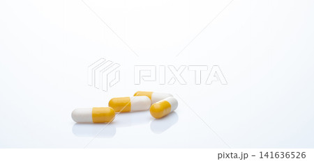 Yellow-white probiotic capsule pill on white background. Probiotic supplement. Gut health. Dietary supplements. Probiotics for a healthy gut. Lactobacillus acidophilus and Bifidobacterium animalis. 141636526