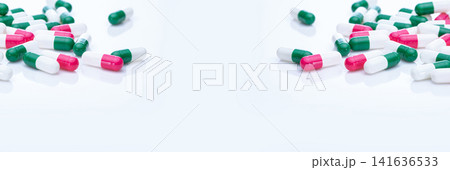 Capsules pill spread on white background. Prescription drugs. Capsule pill frame banner. Green, pink, and white color capsule pills. Pharmaceutical industry. Medication and pharmacology. Health care. 141636533