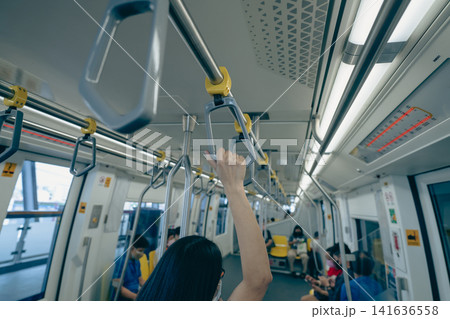 Woman hand firm grip safety handrail in elevated monorail train. Mass transit system in modern city. Inside of electric train. Tourist travel by city sky train. Public transportation. Urban transport. 141636558