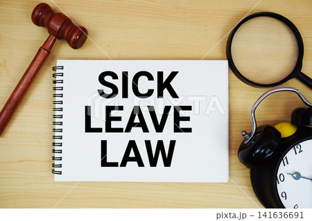 Sick Leave Law text written on notepad with pen, alarm clock and judge gavel on wooden background 141636691